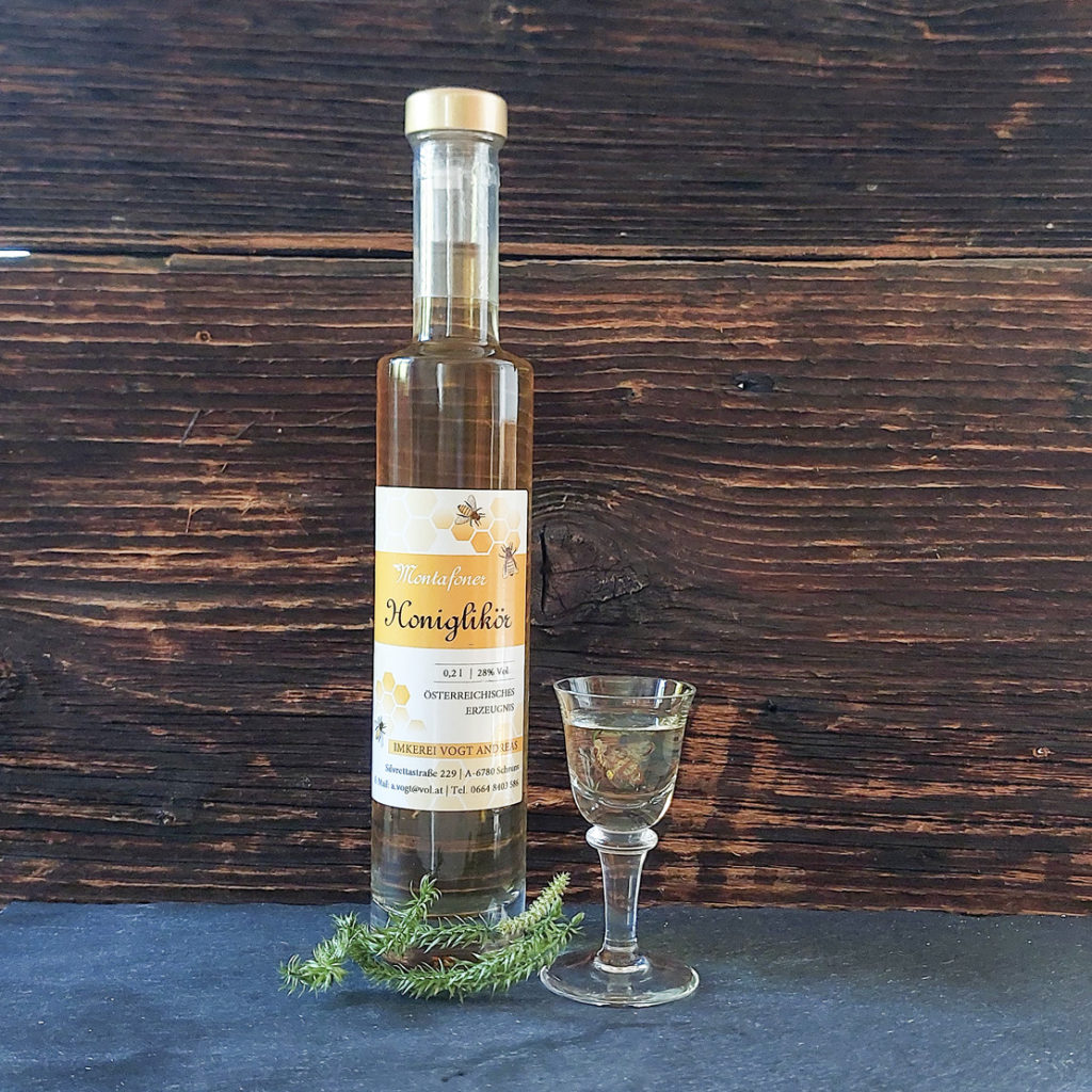 Flasche Honiglikör auf Schieferplatte mit Likörglas