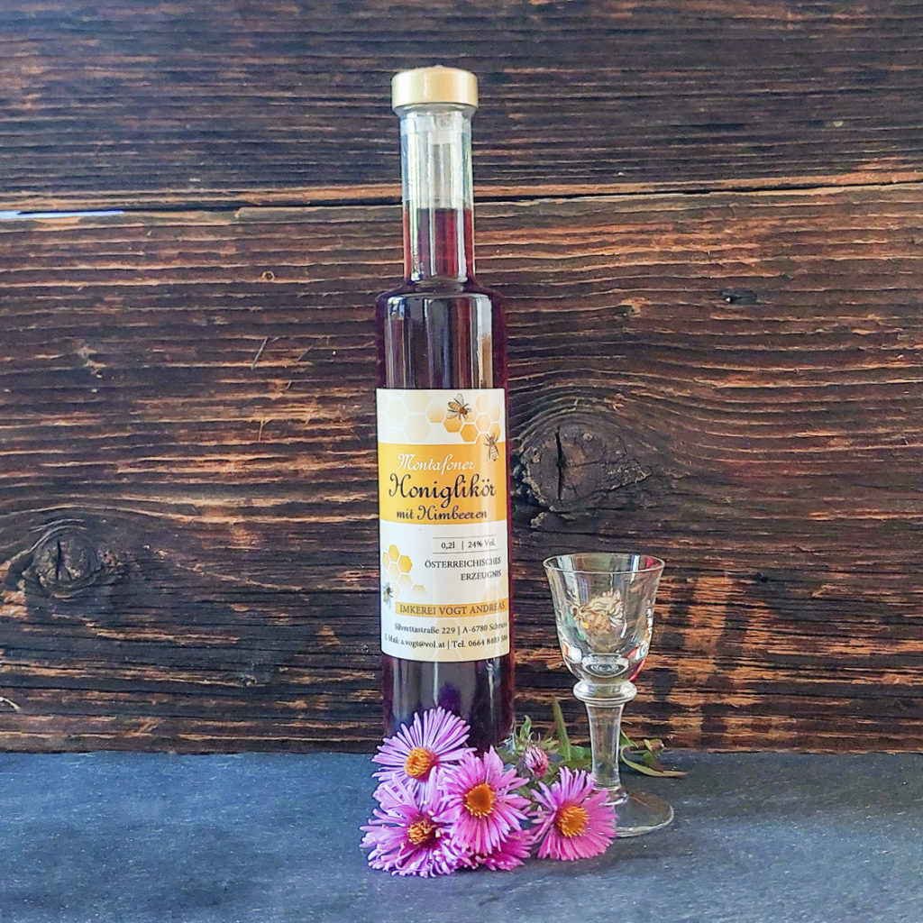 Flasche Honiglikör Himbeere auf Schieferplatte mit Likörglas